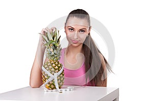 Girl holding pineapple with centimeter