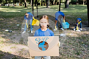 Girl holding placard with globe and