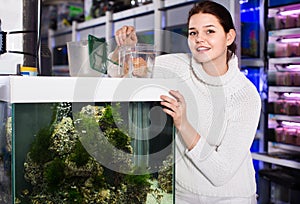 Girl holding plastic container with big colorful fish breed Disc