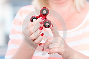 A girl is holding a popular toy fidget spinner in her hands. Stress relief. Anti stress and relaxation fidgets, spinner for tired