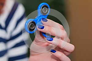 A girl is holding a popular toy fidget spinner in her hands. Stress relief. Anti stress and relaxation fidgets, spinner for tired.