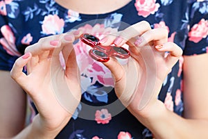 A girl is holding a popular toy fidget spinner in her hands. Stress relief. Anti stress and relaxation fidgets, spinner for tired