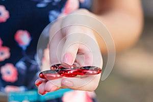 A girl is holding a popular toy fidget spinner in her hands. Stress relief. Anti stress and relaxation fidgets, spinner for tired