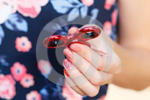 A girl is holding a popular toy fidget spinner in her hands. Stress relief. Anti stress and relaxation fidgets, spinner for tired