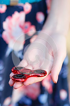 A girl is holding a popular toy fidget spinner in her hands. Stress relief. Anti stress and relaxation fidgets, spinner for tired