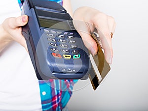 Girl holding a POS terminal, customer is paying by credit card. electronic money and credit card terminal