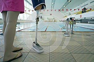 Girl holding prosthetic leg in paralympic sports pool