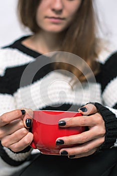 Girl holding a red cup of tea
