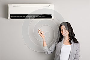 Girl holding a remote control air conditioner photo