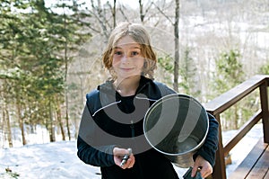 Girl holding a sap bucket and spigot