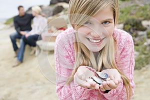 Girl holding shells at beach