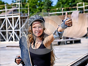 Girl holding a skateboard in hand.