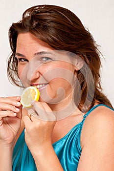 Girl holding a slice of juicy lemon