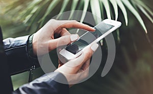 Girl holding smart phone on background sun atmospheric city, hipster using in female hands and texting mobile, street lifestyle