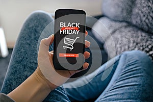 Girl holding smart phone with Black Friday concept on screen