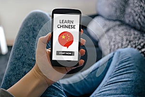 Girl holding smart phone with learn Chinese concept on screen