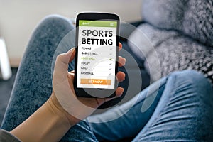 Girl holding smart phone with sports betting concept on screen