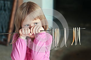 Girl holding stick with artificial sardines at museum