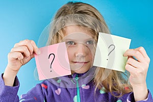 Girl holding a stickers with question marks