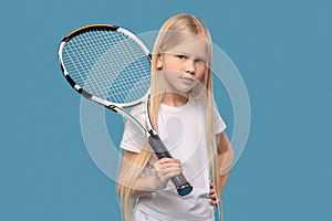 Girl holding tennis racket on her shoulder