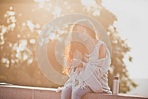 Girl holding a thermos with steaming tea