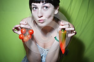 Girl holding tomato and pepper