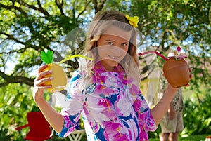 Girl holding tropical drinks at a Hawaiian luau
