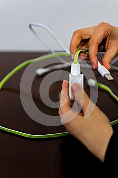 Girl holding two cables and phone charger