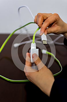 Girl holding two cables and phone charger