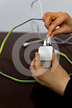 Girl holding two cables and phone charger