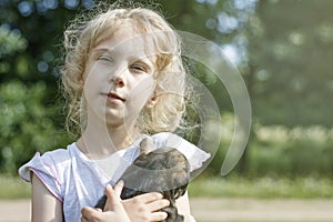 the girl is holding a very small puppy. daylight. close-up