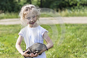 The girl is holding a very small puppy. daylight. close-up