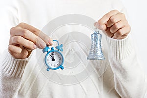 A girl holding a watch and a bell. New Year or Christmas is coming. New Year's concept