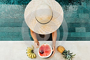 Girl holding watermelon in the blue pool, slim legs, instagram style.