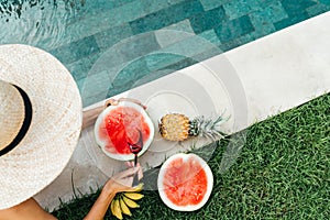 Girl holding watermelon in the blue pool, slim legs, instagram style.