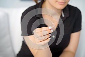 A girl holding a wedding ring doubtfully