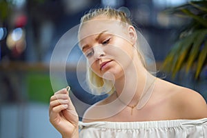 A girl holding a wedding ring doubtfully