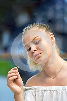 A girl holding a wedding ring doubtfully