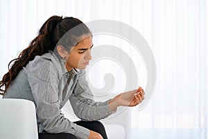 A girl holding a wedding ring doubtfully. Focus on the ring