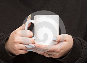 Girl is holding white cup in hands