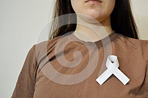 Girl holding white ribbon on her chest. Prisoner& x27;s Day. Day of Non-Violence