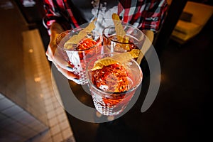 Girl holds alcoholic cocktails negroni with ice and dried honeycombs