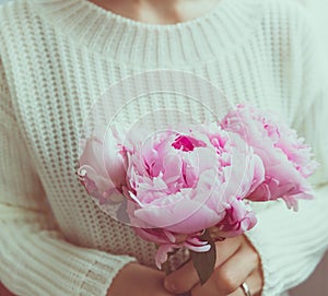 Girl holds beautiful bouquet pink peonies.