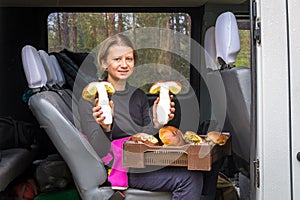 Girl holds big white mushrooms in her hands