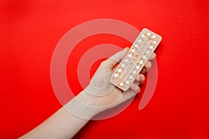 Girl holds birth control pills in her hands. Contraception.