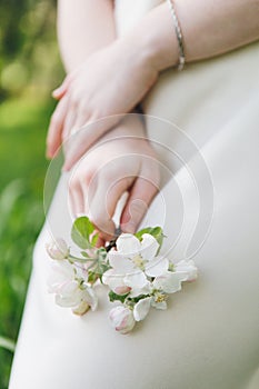 Girl holds a blooming twig in her hands in a spring apple orchard