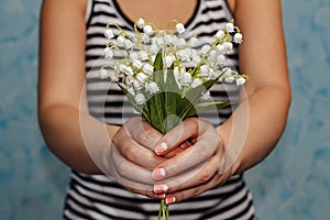 Girl holds a bouquet of lilies of the valley