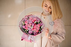 Girl holds bouquet of peonies and roses