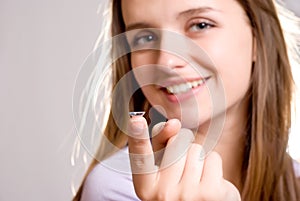 A girl holds a contact lens