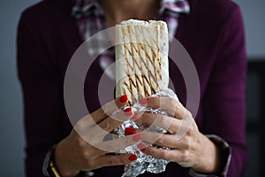 Girl holds delicious shawarma snack during work.